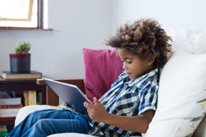 a young boy on a tablet looking at verbal behavior learning